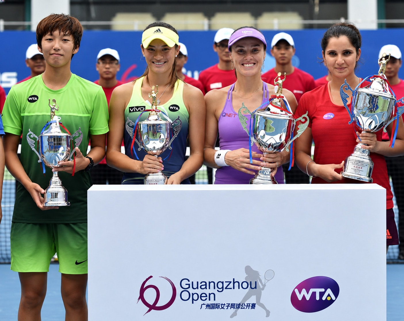 Xu Shilin, left, with the other 2015 Guangzhou Open doubles finalists and their trophies behind the tournament podium.